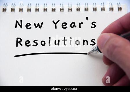Hand writing new year resolution text on notepad. New year's resolution's concept Stock Photo