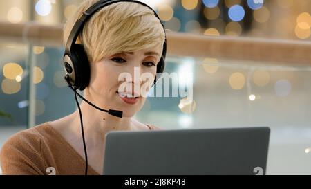 Close-up mature middle aged caucasian woman worker manager agent help line consultant in head microphone talking advises explaining e-learning Stock Photo