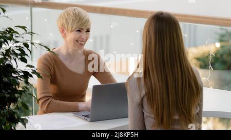 Mature adult 40s female financial advisor agent lawyer insurer consulting caucasian girl client bank service talking with customer explaining Stock Photo