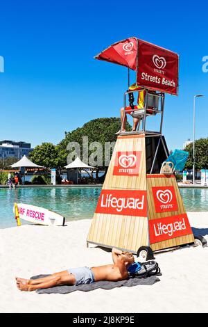 Brisbane Australia / A young man enjoys the sunshine at Streets Beach an urban man made swimming beach. Stock Photo