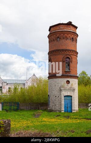 Ancient water tower made of bricks against a cloudy sky. Stock Photo