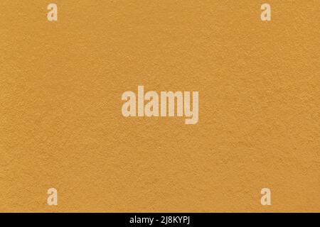 Texture of dark yellow and orange colors paper background, macro. Structure of dense ocher craft cardboard. Felt backdrop closeup. Stock Photo