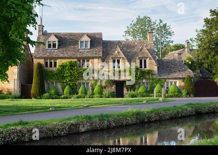 Lower Slaughter cottage in evening spring sunshine. Lower Slaughter, Cotswolds, Gloucestershire, England Stock Photo