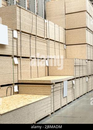 Sheet stack in a construction store. Engineered wood product for load-bearing applications in construction. OSB - Oriented Strand Board. Stock Photo