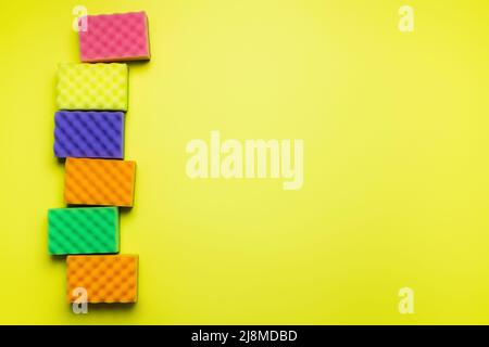 top view of soft multicolored sponges on yellow background Stock Photo