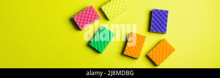 top view of multicolored cleansing sponges on yellow background, banner Stock Photo