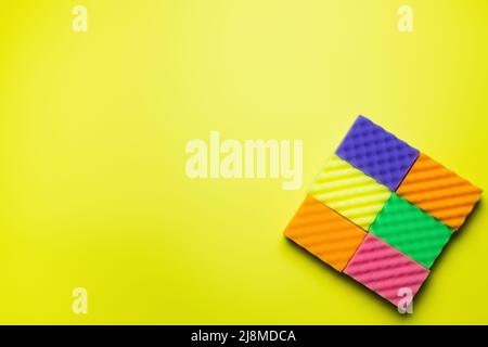 top view of textured multicolored sponges on bright yellow background Stock Photo