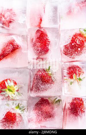 Three rows of ice cubes with strawberries - Top of view. Stock Photo