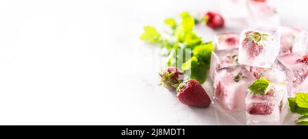 Strawberries frozen in ice cubes with melissa leaves, banner with copy cpace. Stock Photo