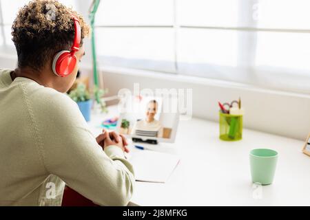 Young student listening teacher on video call online course Stock Photo