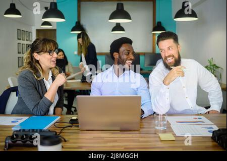 Group of diverse coworkers discussing project in workspace Stock Photo