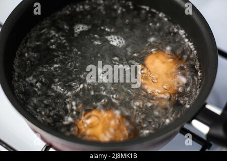 Two brown eggs in a pot of boiling water Stock Photo