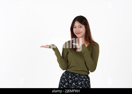 Image of happy young girl standing and Looking camera pointing isolated over white background. Stock Photo