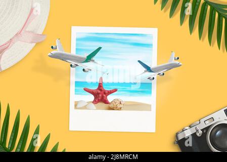 Paper photo of the beach on desk which the planes come out concept. Summer vacation top view, flat lay composition Stock Photo
