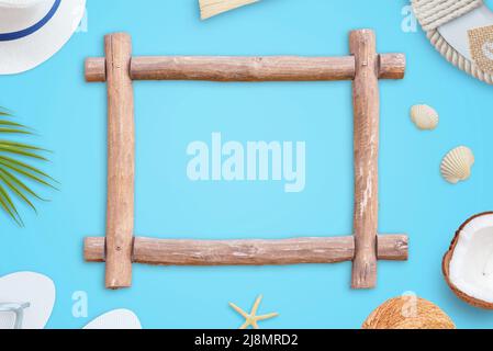 Wooden frame on blue surface. Summer travel concept. Top view, flat lay composition. Free space in the frame for text promotion Stock Photo