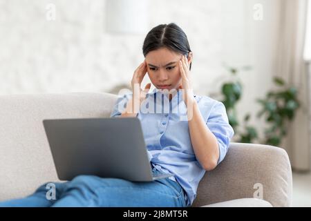 Exhausted asian woman working online from home Stock Photo