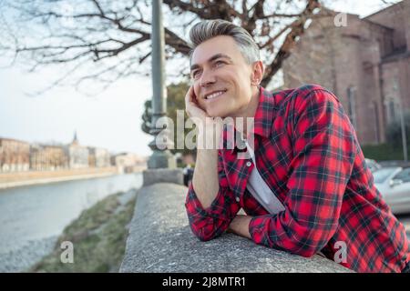 Man standing on embankment leaning on hand Stock Photo