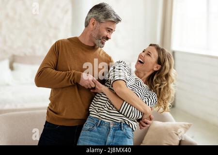 Joyful Couple Dancing And Laughing Having Fun At Home Stock Photo
