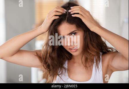 Discontented Woman Suffering From Dandruff Looking At Hair Flakes Indoor Stock Photo