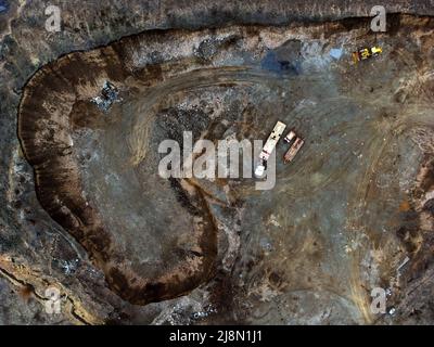 Aerial view from a drone flying above a gravel pit work area construction heavy equipment Stock Photo