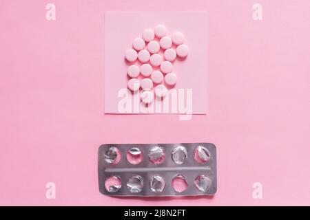 top view of round shape pills on paper note near empty blister pack on pink Stock Photo