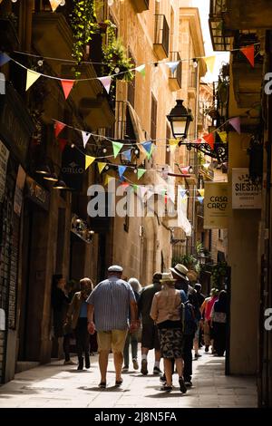 Tourists walking the narrow streets of Barcelona in Barrio Gotico. Stock Photo