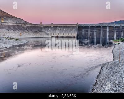 Grand Coulee Dam is one of the largest dams in the United States. On this record temperature day in June at 117/47 degrees (F/C), the sky glowed at ni Stock Photo