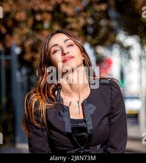 A beautiful 38 year old Spanish woman Beatriz Villacorta takes time to pose for the camera during her lunch break in Dundee, Scotland Stock Photo