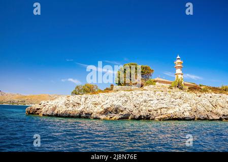 Lighthouse in Port de Pollenca on cliff by Mediterranean sea against blue sky Stock Photo