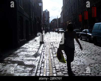 Multimedia digital art of Earlham Street, Covent Garden, London, England, after a rainstorm, moody capital city, woman shopping, tourism, street art. Stock Photo