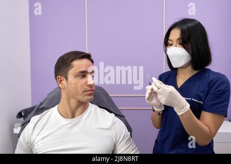 Doctor preparing the injection she will use on a patient for a beauty treatment. Stock Photo