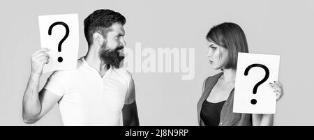 Confused couples with question marks. Conflict between two people. Pensive man and a thoughtful woman, conflict. Portrait of couple holding paper Stock Photo