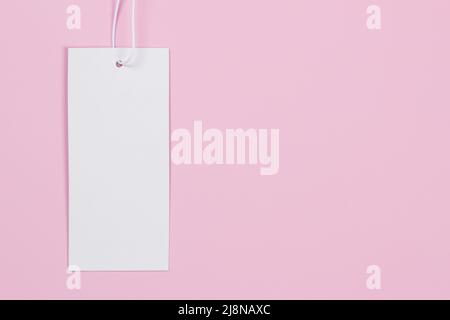 Blank white rectangular label tag on pastel pink background. Price tag tabel mock up. Top view, copy space Stock Photo