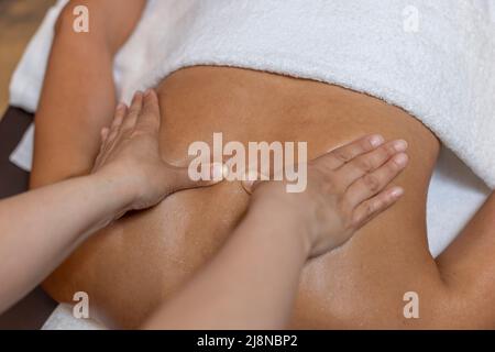 Massage therapist massaging the back of her client. Stock Photo