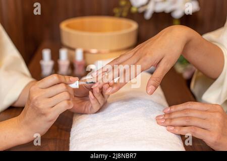 Nail artist polishing nails for client. Stock Photo