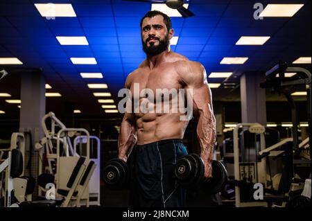 strong bearded male with dumbbells in sport gym Stock Photo