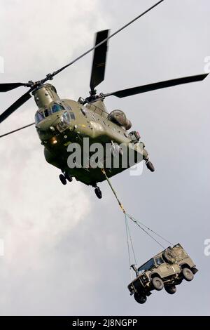 RNAS Yeovilton, Somerset, UK - September 16 2005: A Royal Air Force Boeing Chinook HC.2 (ZH894) carrying an Army Land Rover as an under slung load Stock Photo