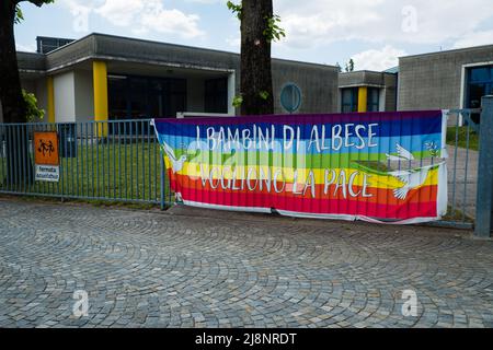 Lombardia, Italy - 05.01.2022: Rainbow flag with Italian text 'The Albese children want peace' (I bambini di Albese vogliono pace) Stock Photo
