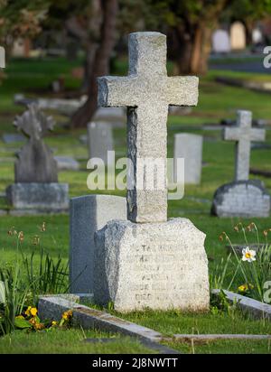 A stone cross grave marker in Ross Bay Cemetery in Victoria, British Columbia, Canada. Stock Photo