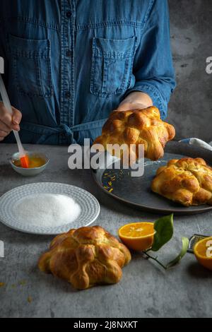 Woman preparing Pan de muertos bread of the dead for Mexican day of the dead. Stock Photo