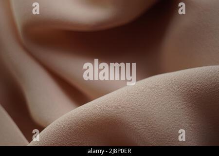 Delicate pale brown thin fabric, beige material chiffon waves. Stock Photo