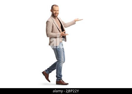 Full length shot of a young man with a headset showing something with hands isolated on white background Stock Photo
