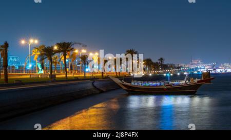 Doha, Qatar- May 05,2022:View of qatar Corniche during night with a colorful decorated traditional dhow Stock Photo