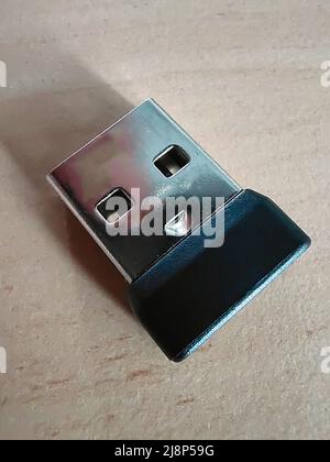 USB connector for a wireless computer mouse close-up on a wooden surface Stock Photo
