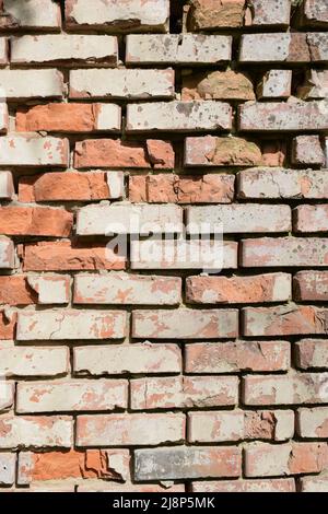 Old cracked brick wall with deep gaps between the blocks and crumbling Stock Photo