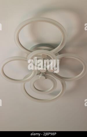 Suspended white LED chandelier that lights up with remote control Stock Photo
