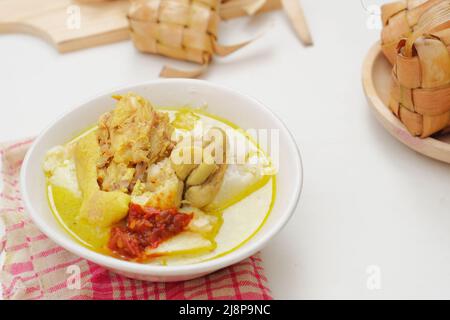 Opor Ayam is served on a white background. Opor is a traditional Indonesian food made from chicken cooked with coconut milk sauce Stock Photo