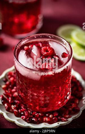 Close up of Pomegranate Margarita with Pink Salt and Raspberries Stock Photo