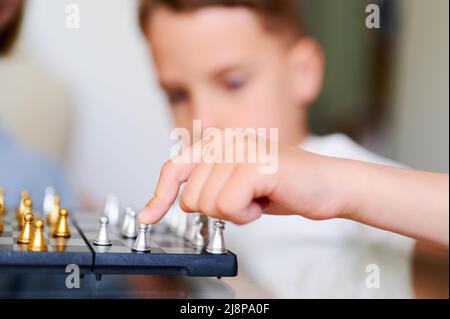 Caucasian Mother And little Son Playing Chess At Home Stock Photo