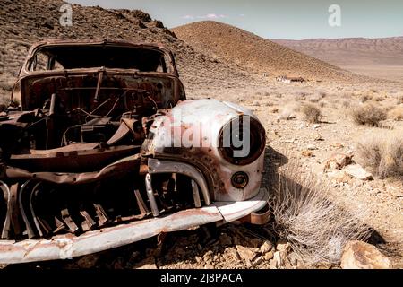 Old rusty abandoned vintage antique car in the desert